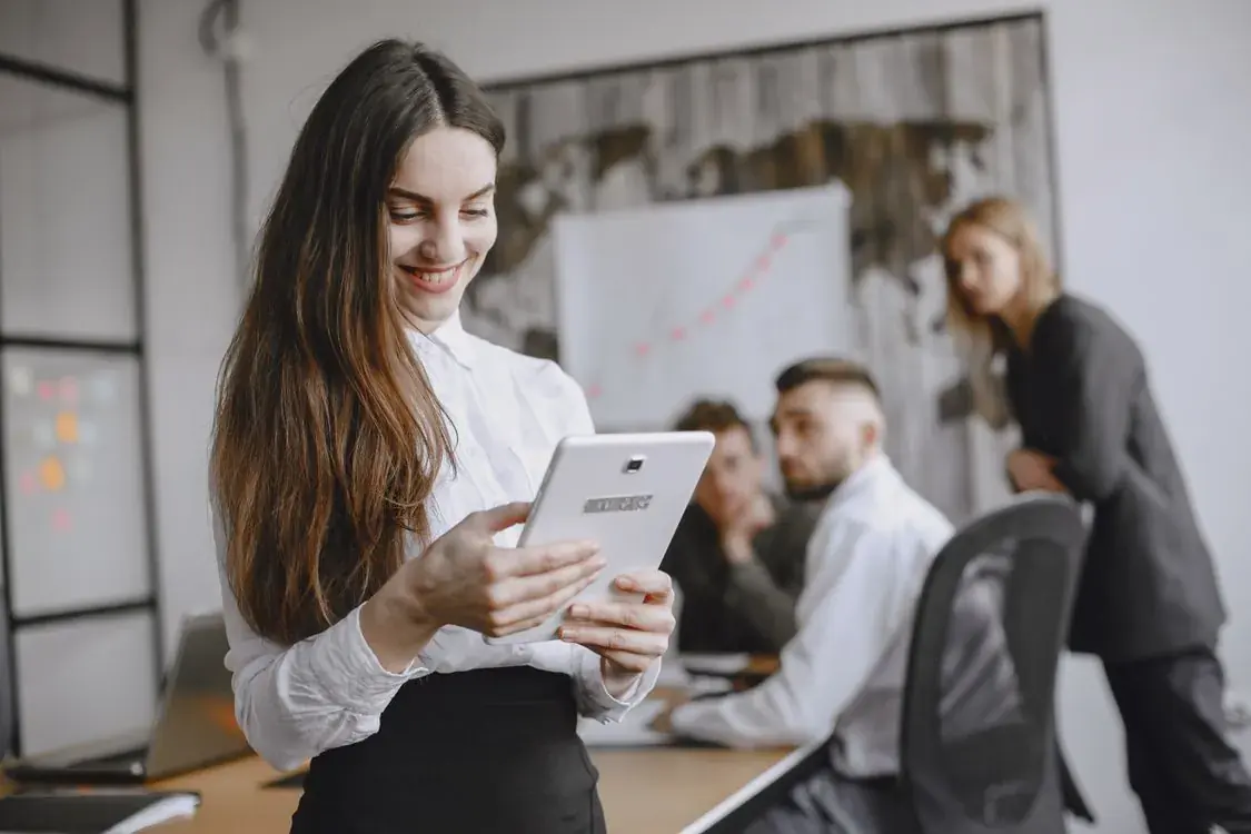 A professional using a tablet during a meeting in a modern office