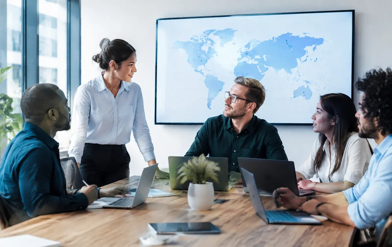 Business team collaborating around a table representing coordinated global mobility management