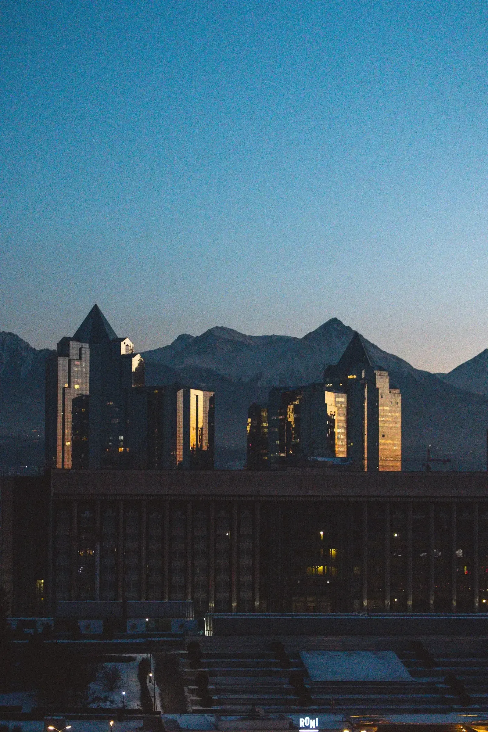 A modern cityscape in Kazakhstan at dusk, representing the country's tightening foreign worker quota for 2027.